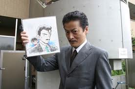 Jinnai dressed as Kogoro holding a drawing of his character.
